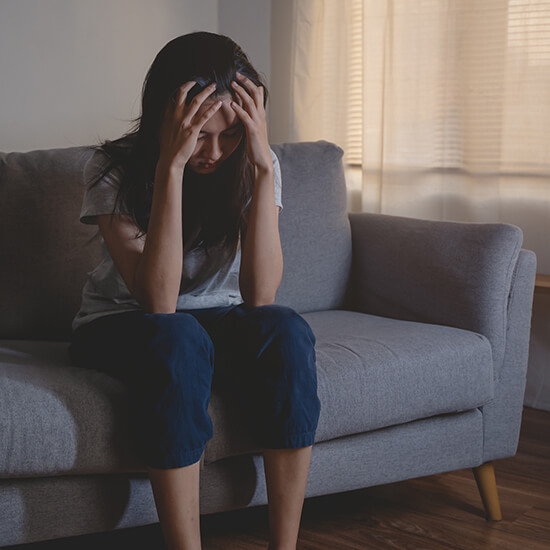 Young girl sitting on a sofa - mental health and age concept