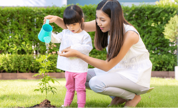 Mother and Child Watering a Growing Tree Implying Good Health